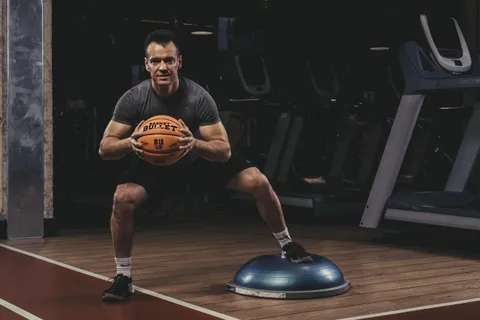 Ćwiczenie równoważne na BOSU z piłką lekarską Basket Bullet