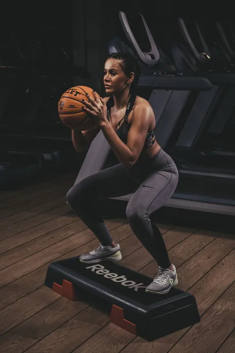 Przysiady na stopniu z piłką lekarską Basket Bullet